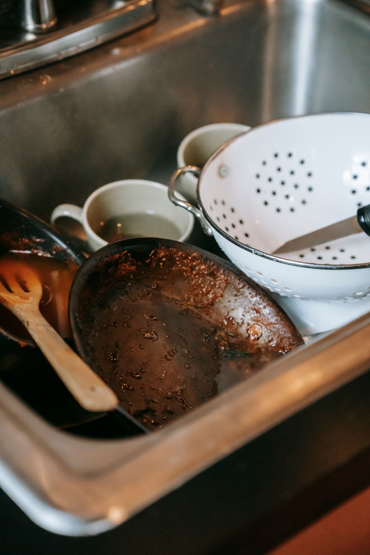 Temporary stock photo of dirty dishes in a kitchen sink before cleaning.